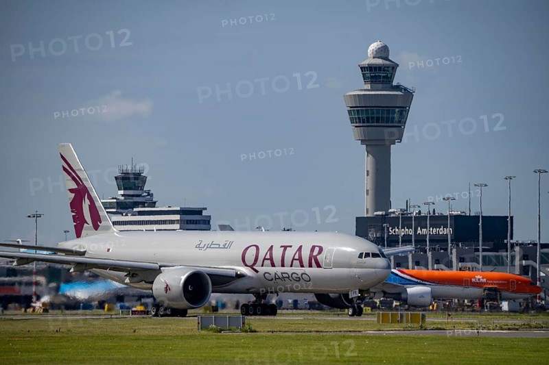 Aircraft at Amsterdam Schiphol Airport, on the taxiway for take-off on the Aalsmeerbaan, 18L/36R, Qatar Cargo aircraft, Boeing 777-200, air traffic control tower, terminal, Netherlands
