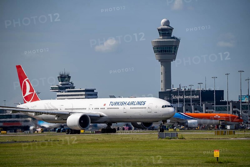Aircraft at Amsterdam Schiphol Airport, on the taxiway for take-off on the Aalsmeerbaan, 18L/36R, Turkish Airlines Boeing 777-3F2, air traffic control tower, terminal, Netherlands