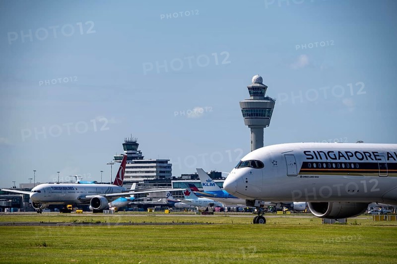 Aircraft at Amsterdam Schiphol Airport, on the taxiway for take-off on the Aalsmeerbaan, 18L/36R, Singapore Airlines A350-900, air traffic control tower, terminal, Netherlands