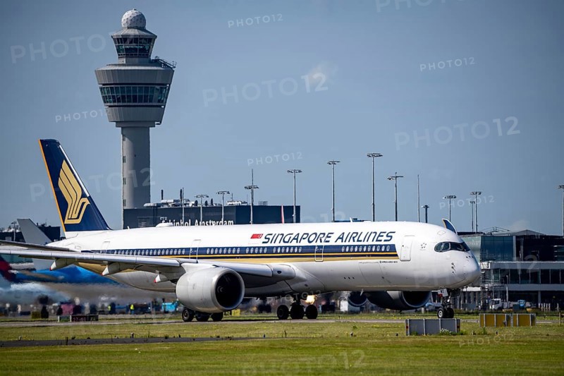 Aircraft at Amsterdam Schiphol Airport, on the taxiway for take-off on the Aalsmeerbaan, 18L/36R, Singapore Airlines A350-900, air traffic control tower, terminal, Netherlands