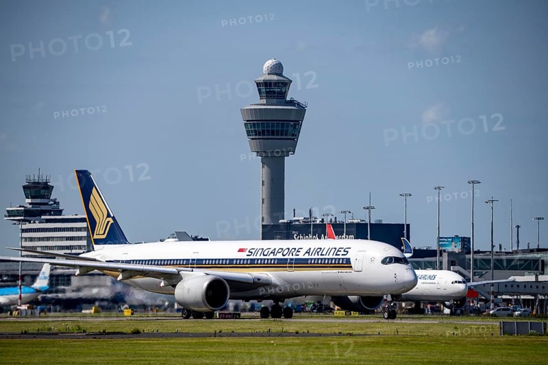 Aircraft at Amsterdam Schiphol Airport, on the taxiway for take-off on the Aalsmeerbaan, 18L/36R, Singapore Airlines A350-900, Turkish Airlines Boeing 777-3F2, air traffic control tower, terminal, Netherlands