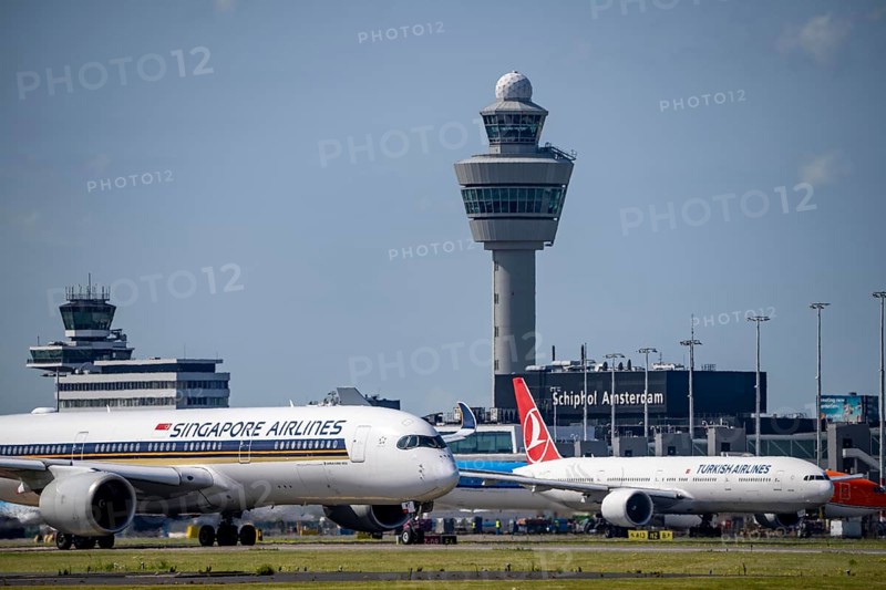 Aircraft at Amsterdam Schiphol Airport, on the taxiway for take-off on the Aalsmeerbaan, 18L/36R, Singapore Airlines A350-900, Turkish Airlines Boeing 777-3F2, air traffic control tower, terminal, Netherlands