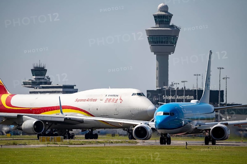 Suparna Airlines Cargo Boeing 747 and KLM Boeing 737-8K2, aircraft at Amsterdam Schiphol Airport, on the taxiway for take-off on the Aalsmeerbaan, 18L/36R, air traffic control tower, terminal, Netherlands