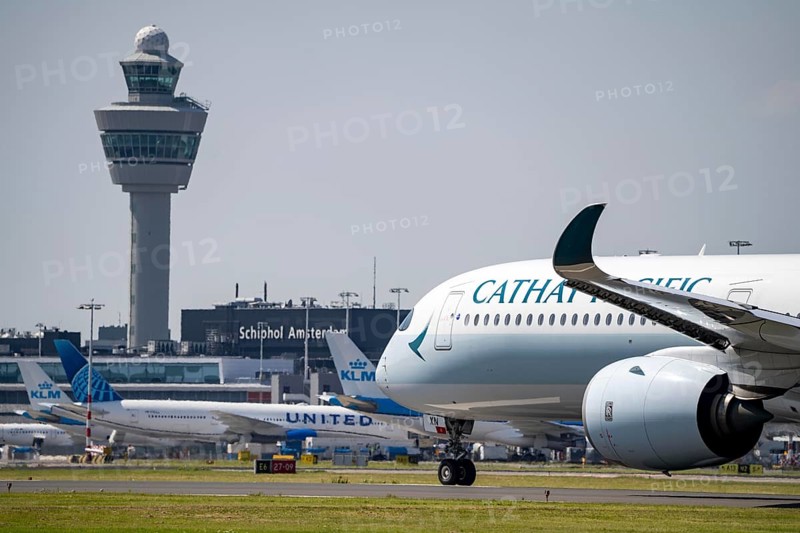 Cathay Pacific aircraft at Amsterdam Schiphol Airport, shortly in front of take-off on the Aalsmeerbaan, 18L/36R, air traffic control tower, terminal, Netherlands