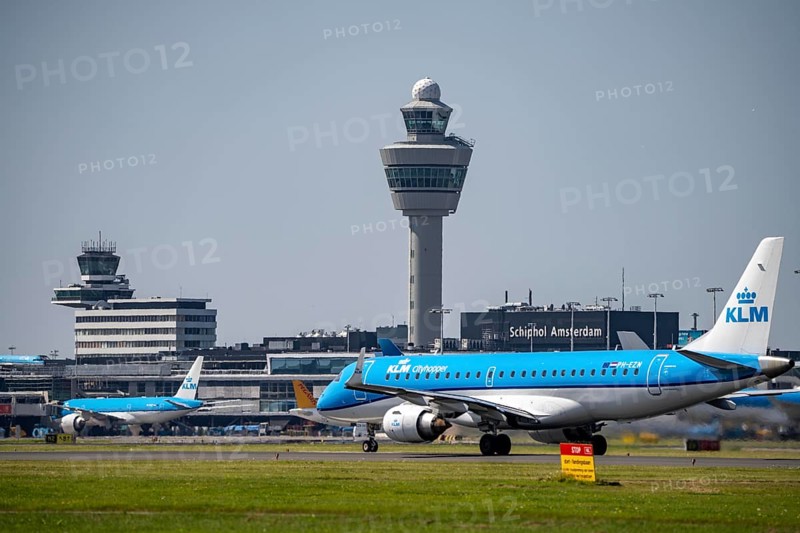 KLM cityhopper Embraer E190STD, aircraft at Amsterdam Schiphol Airport, shortly in front of take-off on the Aalsmeerbaan, 18L/36R, air traffic control tower, terminal, Netherlands