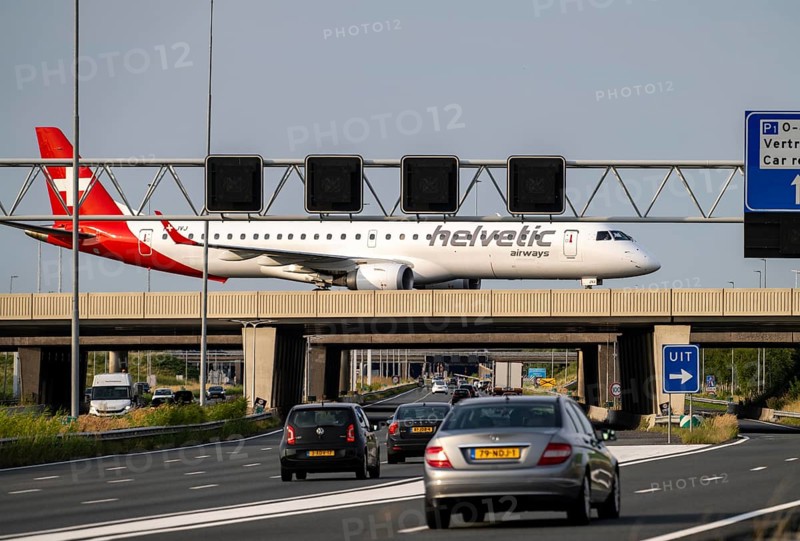 Amsterdam Schiphol Airport, Helvetic Airways Embraer ERJ-195, aircraft on the taxiway, bridge over the A4 motorway, connection from the Polderbaan runway to the terminal, Netherlands