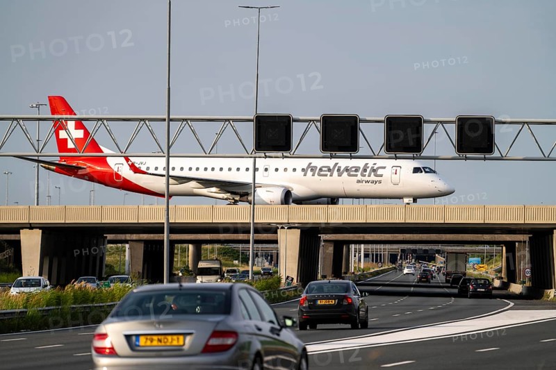 Amsterdam Schiphol Airport, Helvetic Airways Embraer ERJ-195, aircraft on the taxiway, bridge over the A4 motorway, connection from the Polderbaan runway to the terminal, Netherlands