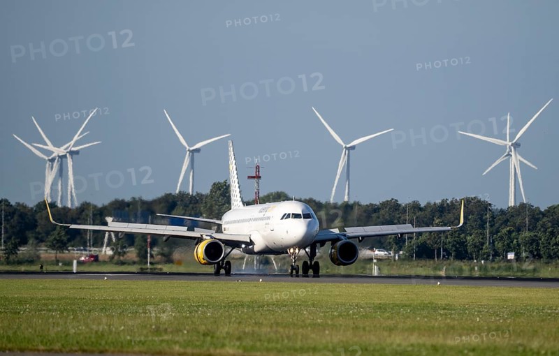 Vueling.com aircraft landing at Amsterdam Schiphol Airport, Polderbaan, 18R/36L, wind farm in the background, Netherlands