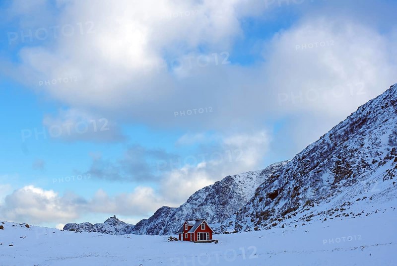 A lonely red house in the middle of a snowy winter landscape in front of majestic mountains, Nyksund, Vesteralen, Andoya, Nordland, Arctic, Norway, Europe