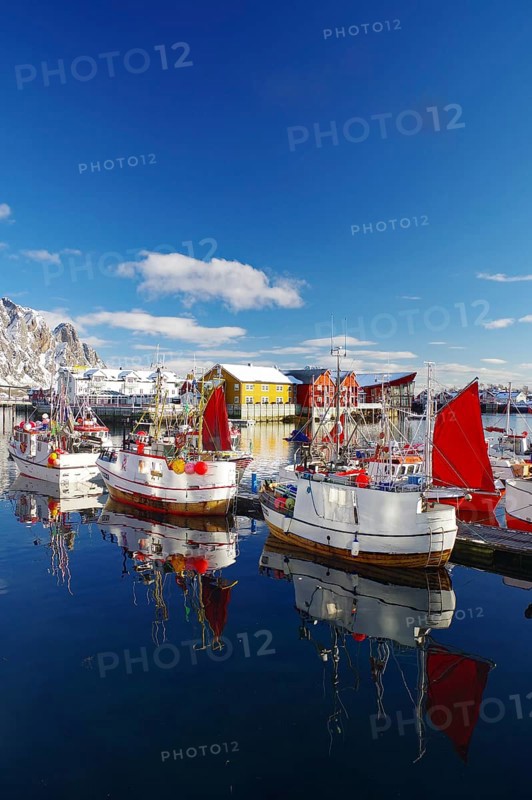 Fishing boats with red sails lying calmly on the quay, reflected in the water, surrounded by snow-capped mountains, fishing, Lofoten, Svolvaer, Nordland, Arctic, Norway, Europe