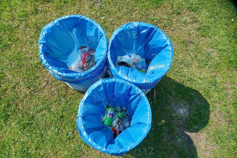 Rubbish bins with blue bin liners standing in a meadow, top view, Germany, Europe