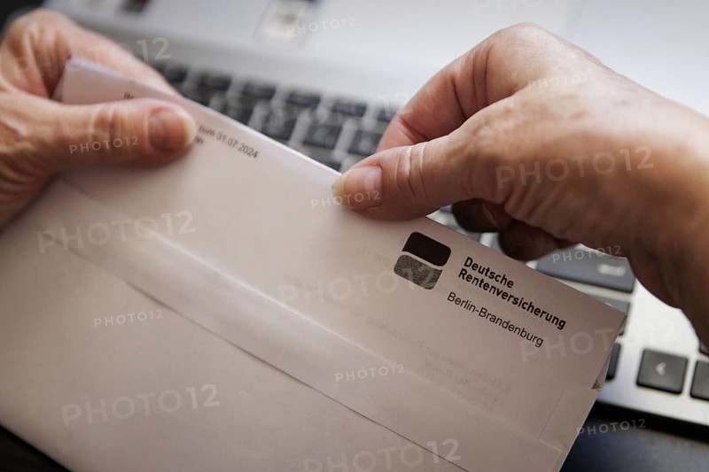 An elderly woman opens a letter from Deutsche Rentenversicherung. Berlin, 05.08.2024