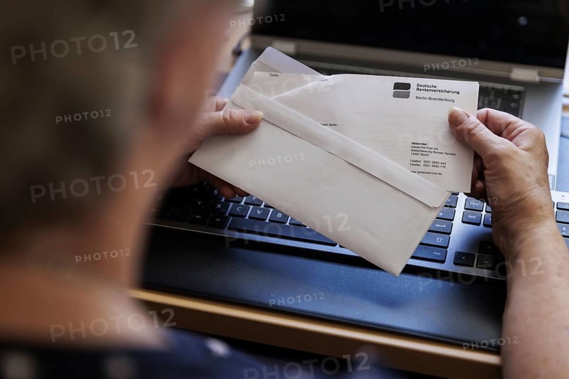 An elderly woman opens a letter from Deutsche Rentenversicherung. Berlin, 05.08.2024
