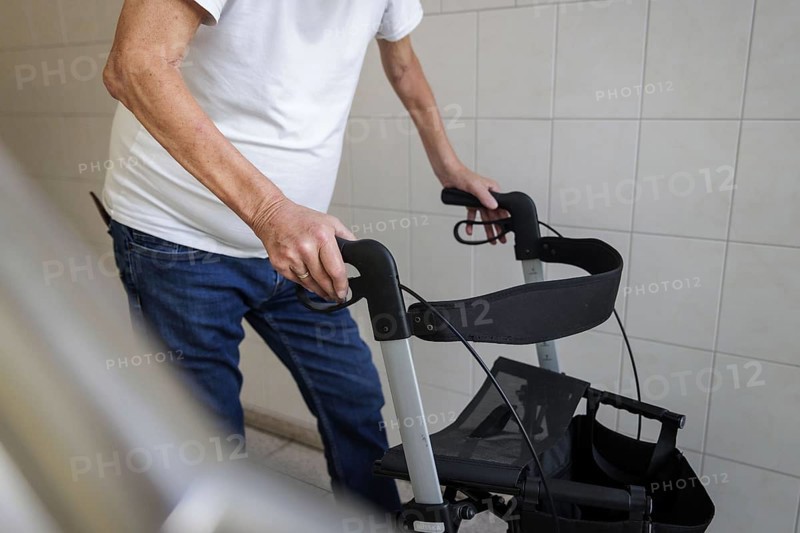 An elderly man walks with a rollator through a hallway in Berlin, 05/08/2024
