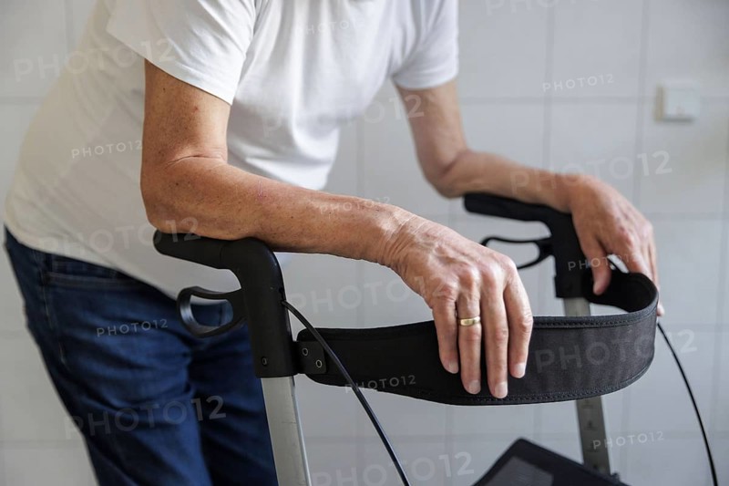 An elderly man walks with a rollator through a hallway in Berlin, 05/08/2024