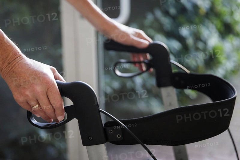 An elderly man walks with a rollator through a hallway in Berlin, 05/08/2024