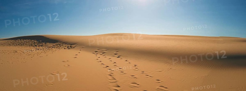 Sand dunes with blue sky and sun