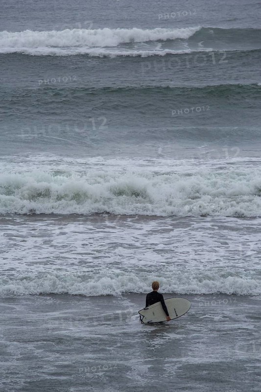 A surfer enters the water on an ideal day for surfing along the Wild Atlantic Way. Strandhill, Sligo, Ireland, Europe