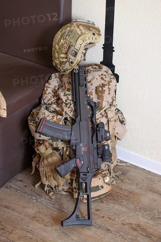 A military helmet and a rifle lie on a camouflaged rucksack on a wooden floor, mobilisation, Bundeswehr