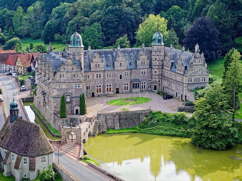 Aerial view of Hämelschenburg Castle, built in the Weser Renaissance style, with gardens, pond and church. The castle is located on the Weser Renaissance Road and the Lower Saxony Trail. Emmerthal, Weserbergland, Lower Saxony, Germany, Europe