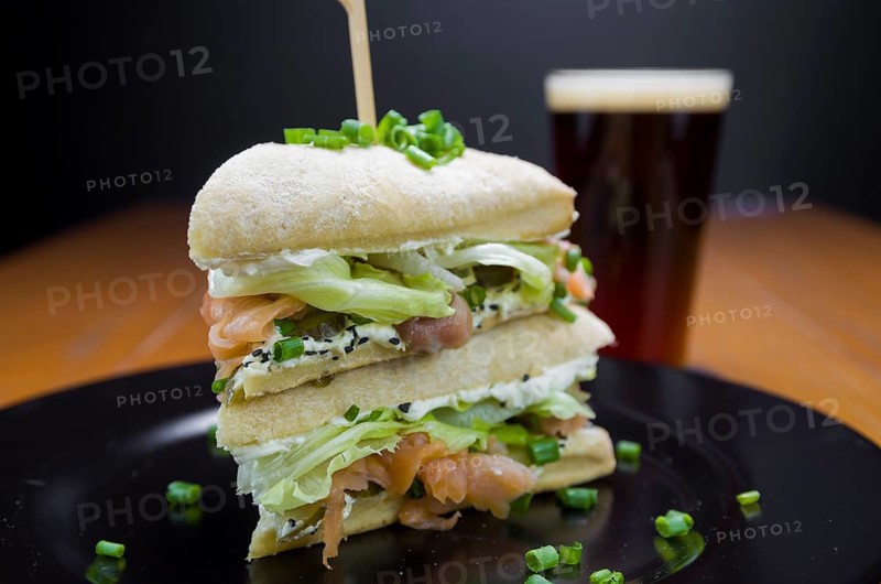 Delicious salmon sandwich close-up and glass of beer