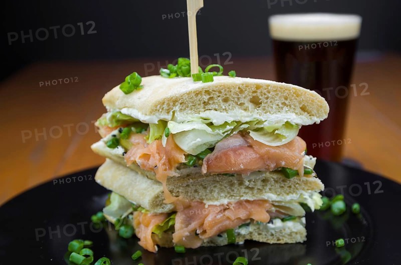 Delicious salmon sandwich close-up and glass of beer