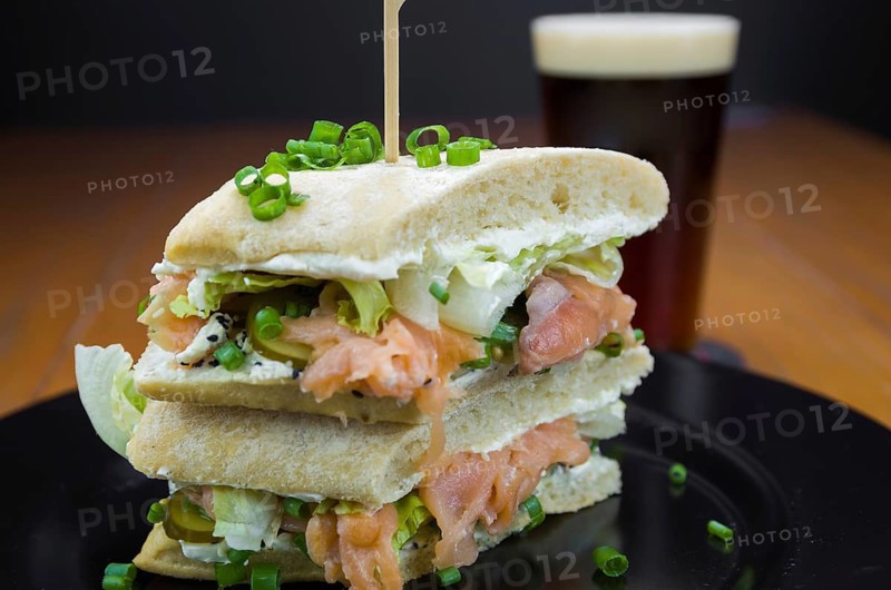 Delicious salmon sandwich close-up and glass of beer