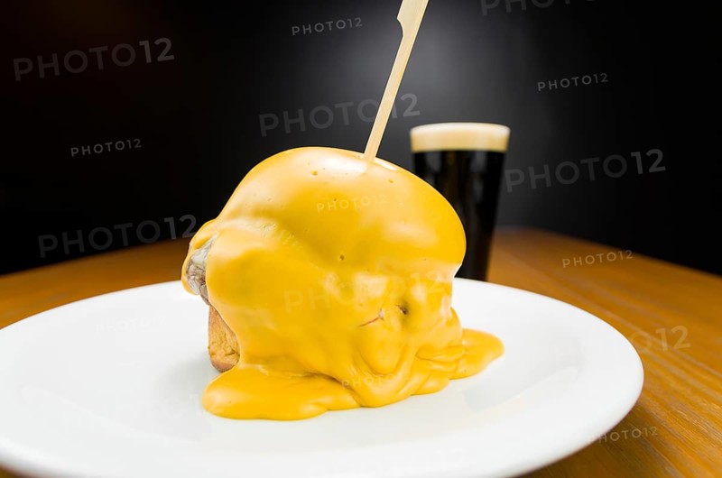 Delicious close-up of hamburger covered in cheddar cheese sauce