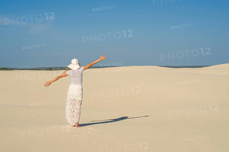 Young woman walking in the dunes, desert