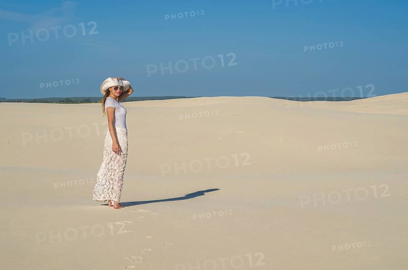 Young woman walking in the dunes, desert