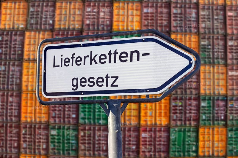 Symbolic image Supply Chain Act: Directional arrow with the inscription LIEFERKETTENGESETZ in front of a large stack of shipping containers (Composing)
