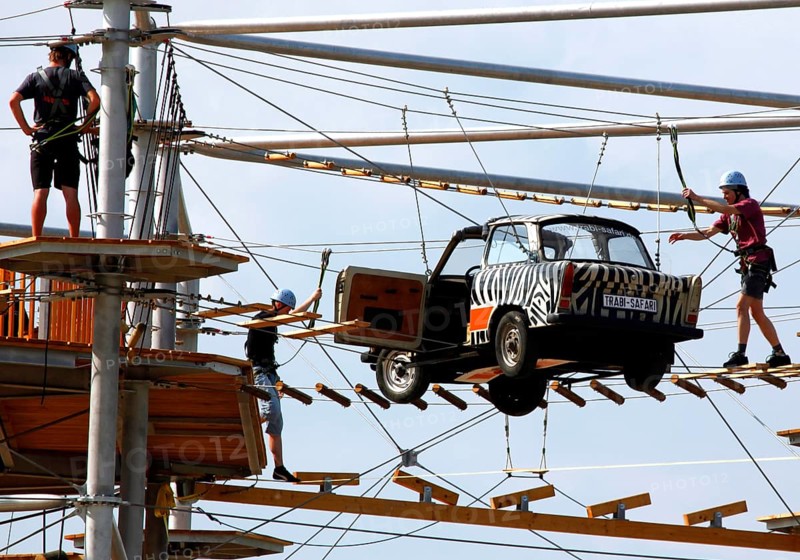 Berlin, 31.07.2010, Climbers balance over a Trabant suspended on ropes in the high ropes course Mount Mitte, Berlin, Germany, Europe