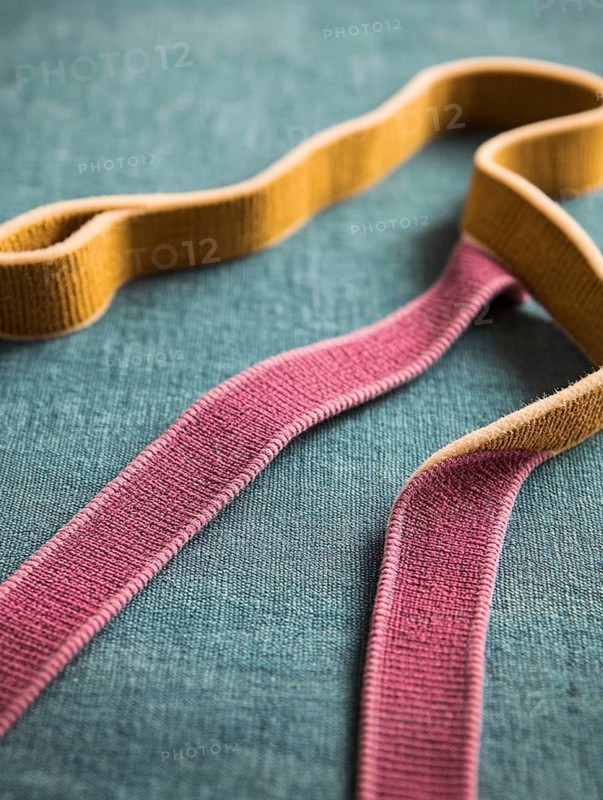 Colorful fabric ribbons laid out on a blue textured background, AI generated