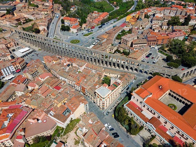 Aerial view of a city crossed by a long, historic aqueduct, surrounded by tiled roofs and street crossings, Aerial view, Aqueduct, Segovia, Castilla y Leon, Leon, Spain, Europe