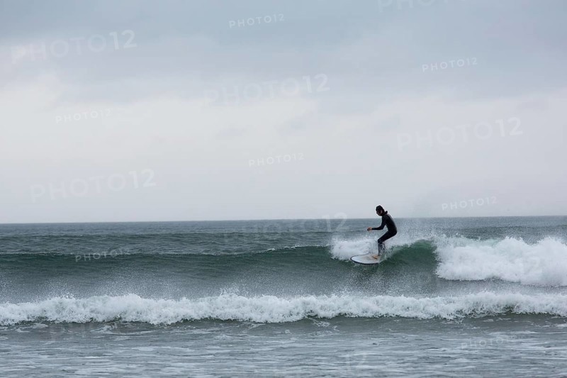A surfer enjoys the high waves at Strandhill along Wild Atlantic way on the west coast of Ireland., Sligo, Ireland, Europe