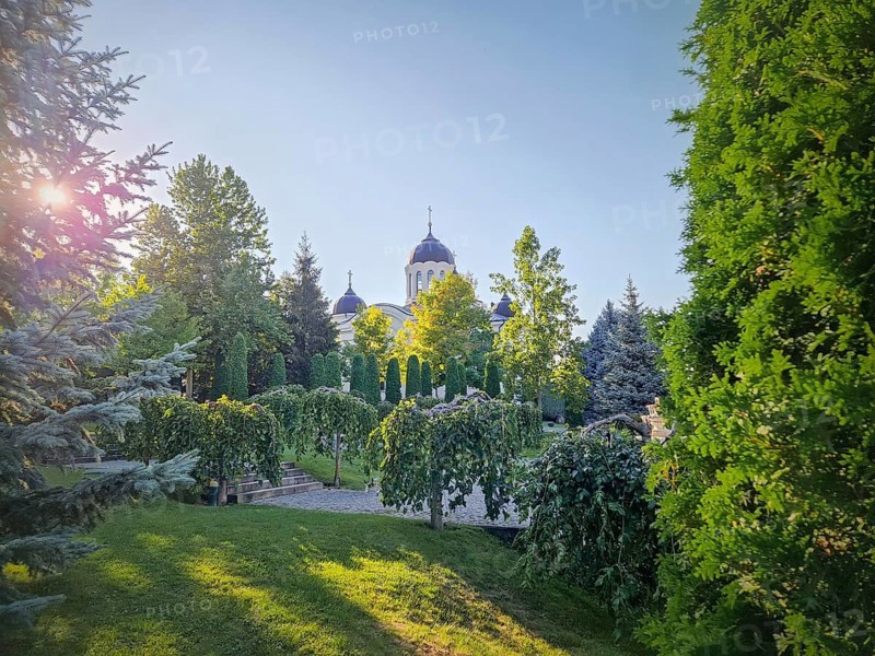 Curchi Monastery outdoor view. Christian Orthodox style church traditional for eastern Europe culture located in Orhei, Moldova. Beautiful garden with green trees around basilica