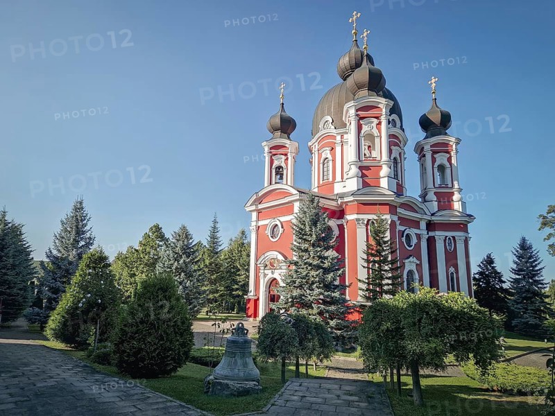 Curchi Monastery outdoor view. Christian Orthodox style church traditional for eastern Europe culture located in Orhei, Moldova. Beautiful garden with trees around the basilica and the big bell