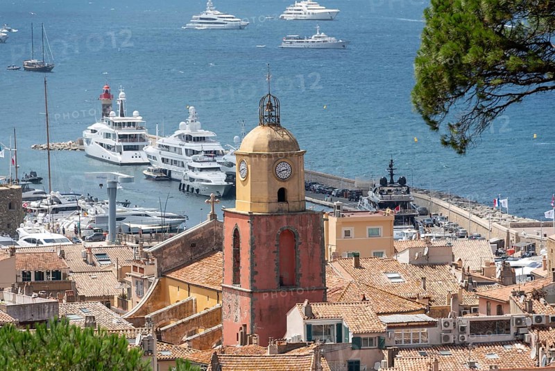 View over the roofs of Saint Tropez with the church Notre-Dame de l'Assomption, behind it the bay of Saint Tropez with numerous boats, Saint Tropez, Provence-Alpes-Côte d'Azur, France, Europe