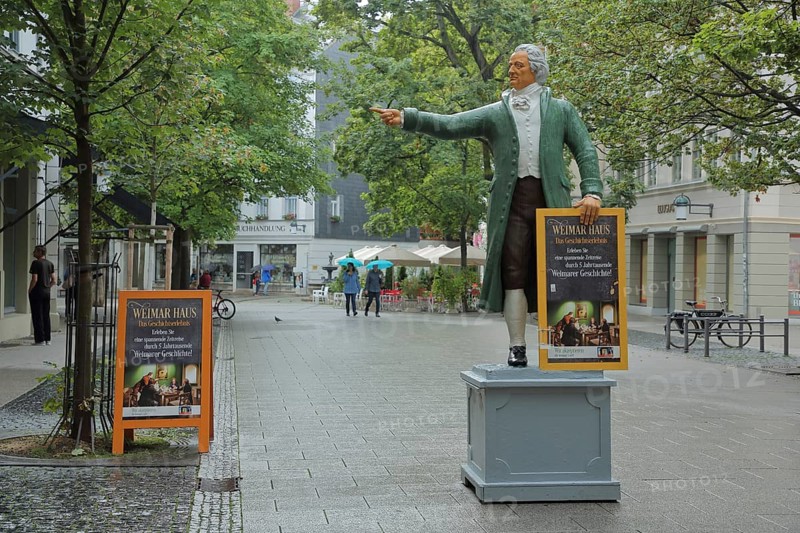 Sculpture of Johann Wolfgang von Goethe in historical clothing and poster signposting the way to the Weimar House, pedestrian, Weimar, Thuringia, Germany, Europe