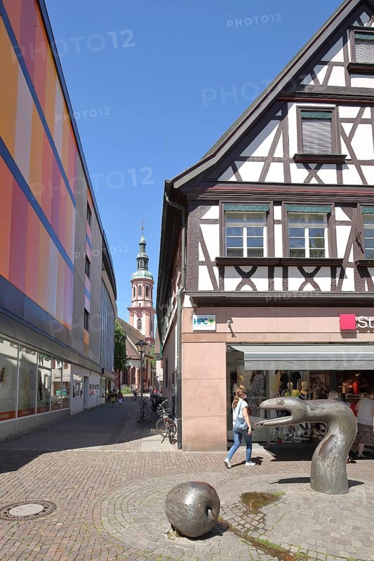Sculpture snake by Franz Gutmann and view into the Pfarrstrasse with the tower of the Heilig Kreuz church, snake figure, animal figure, apple figure, main street, Offenburg, Ortenau, Baden-Württemberg, Germany, Europe