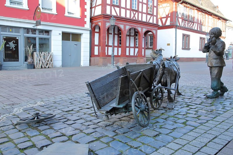 Sculpture goat cart with boy and broken cart, wheel, cart wheel, cart, cart, wagon, broken down, broken axle, break, damage, broken, lost, defective, destroyed, broken, fright, fear, fearful, fear, child, goat figure, half-timbered house, town hall, Gross-Gerau, Hesse, Germany, Europe