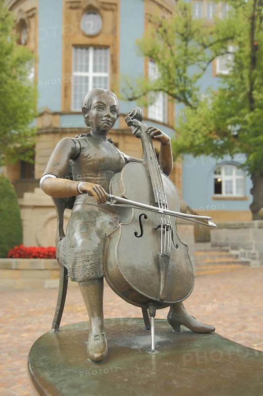 Musicians' fountain with cello player by Bonifatius Stirnberg 1989 in front of the blue town hall, blue, sculpture, woman, bronze, musician, cello player, making music, chair, sitting, detail, Donaueschingen, Southern Black Forest, Black Forest, Baden-Württemberg, Germany, Europe