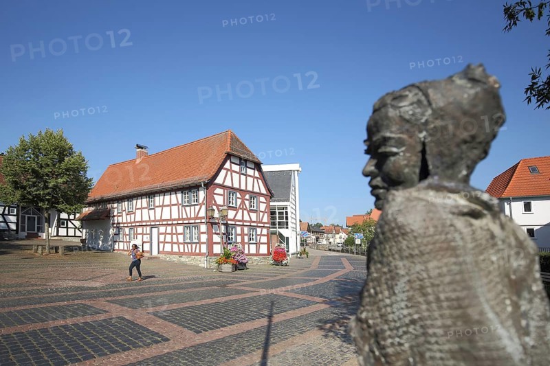 Museum of local history and blurred sculpture Sitting Soraya by Karlheinz Oswald 2017, half-timbered house, bronze, sitting, woman, Eschenplatz, Eschborn, Hesse, Germany, Europe
