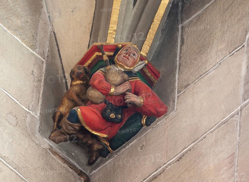 Jester with dog and bagpipes, Consol Stone in Heilig Kreuz Minster, Rottweil, Baden-Württemberg, Germany, Europe