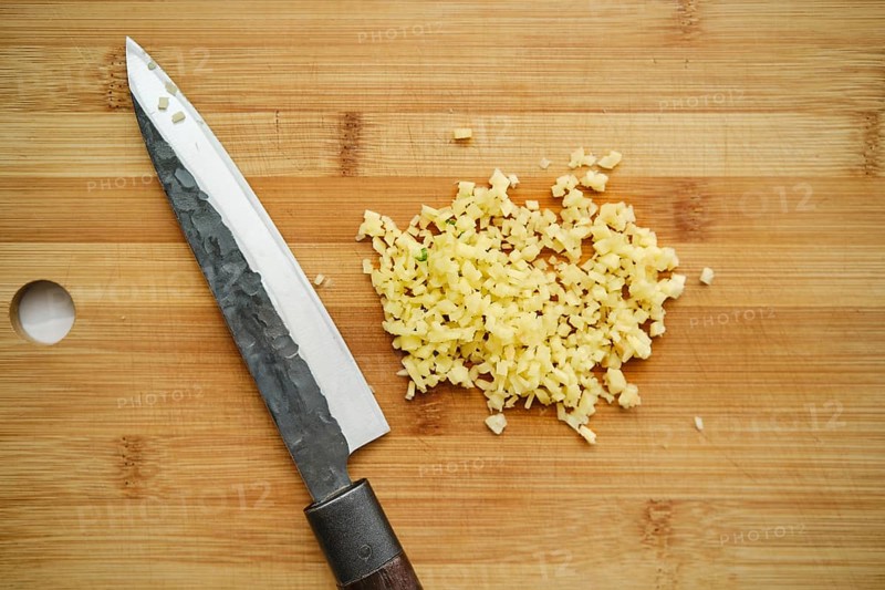 Overhead view of chopped ginger on cutting board