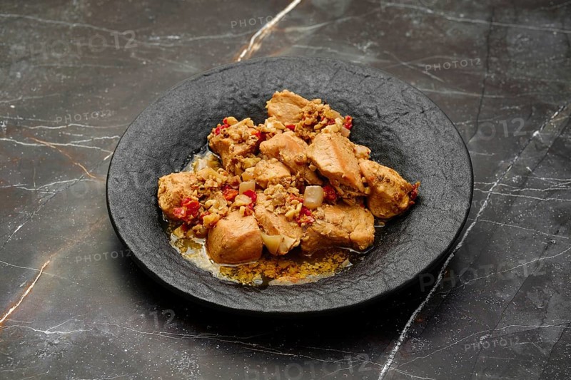 Traditional Georgian meal, kharcho, chicken fillet ragout with walnuts