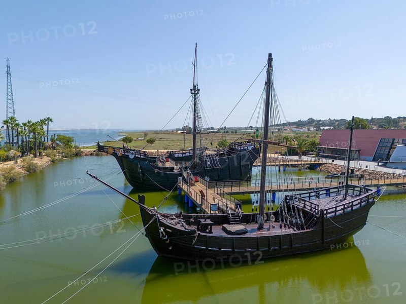 Resting harbour with historical replicas of sailing ships in the water under a clear sky, aerial view, Muelle de las Carabelas, reproductions of La Nina, La Pinta and La Santa Maria, Museum, Palos de la Frontera, Province of Huelva, Andalusia, Spain, Europe