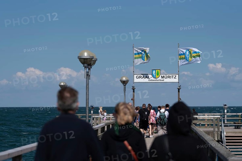 Holidaymakers on the pier, flags in the background, Graal-Müritz, Mecklenburg-Vorpommern, Germany, Europe