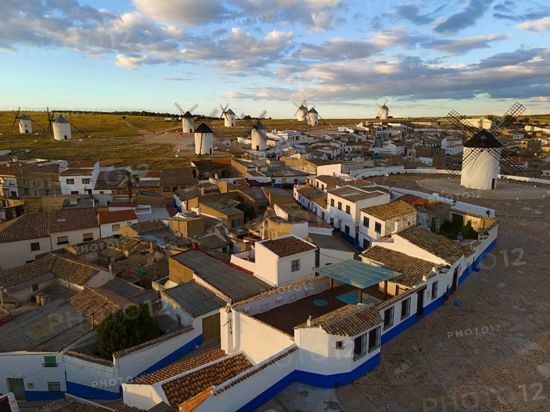 Aerial view of a Spanish village with traditional white houses and windmills under a blue sky with clouds, aerial view, windmills, Campo de Criptana, Ciudad Real province, Castilla-La Mancha, Route of Don Quixote, Spain, Europe