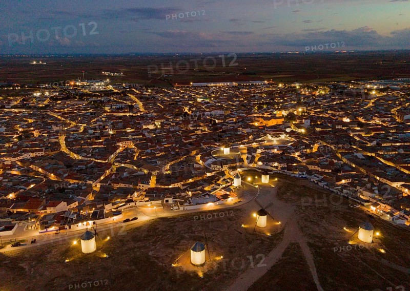 Night view of a village with illuminated windmills. The streets of the village are illuminated by lights and the surroundings appear calm and quiet. Aerial view, windmills, Campo de Criptana, Province of Ciudad Real, Castilla-La Mancha, Route of Don Quixote, Spain, Europe